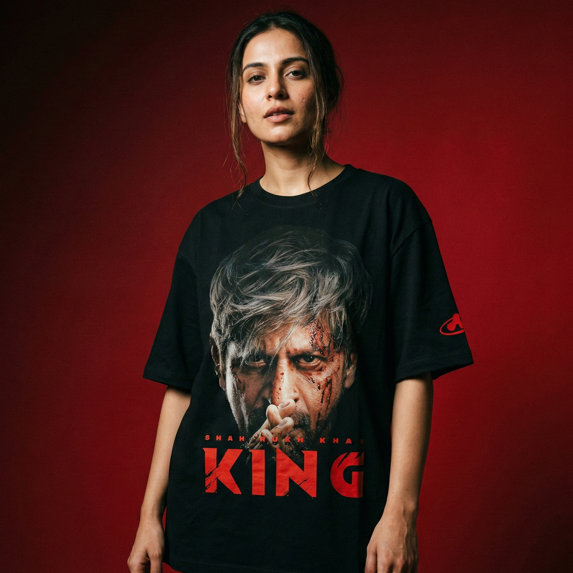 Person wearing a black t-shirt with a graphic design and the word 'KING' on a red background